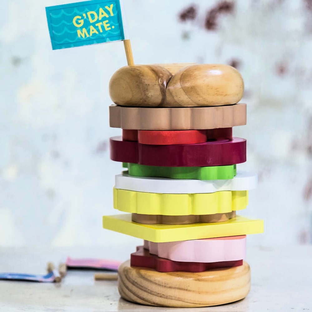 Wooden Aussie stacking burger toy for kids with colourful layers, mini flags, and chunky pieces—perfect for imaginative food play and motor skill development.