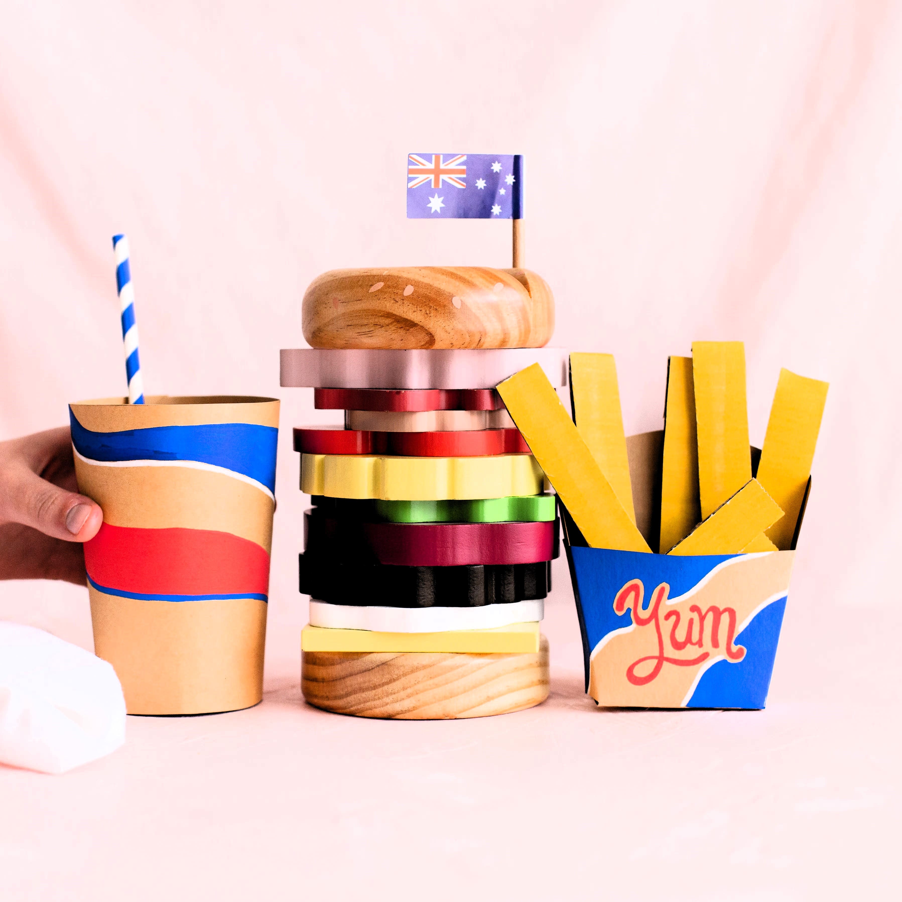 Wooden Aussie stacking burger toy for kids with colourful layers, mini flags, and chunky pieces—perfect for imaginative food play and motor skill development.