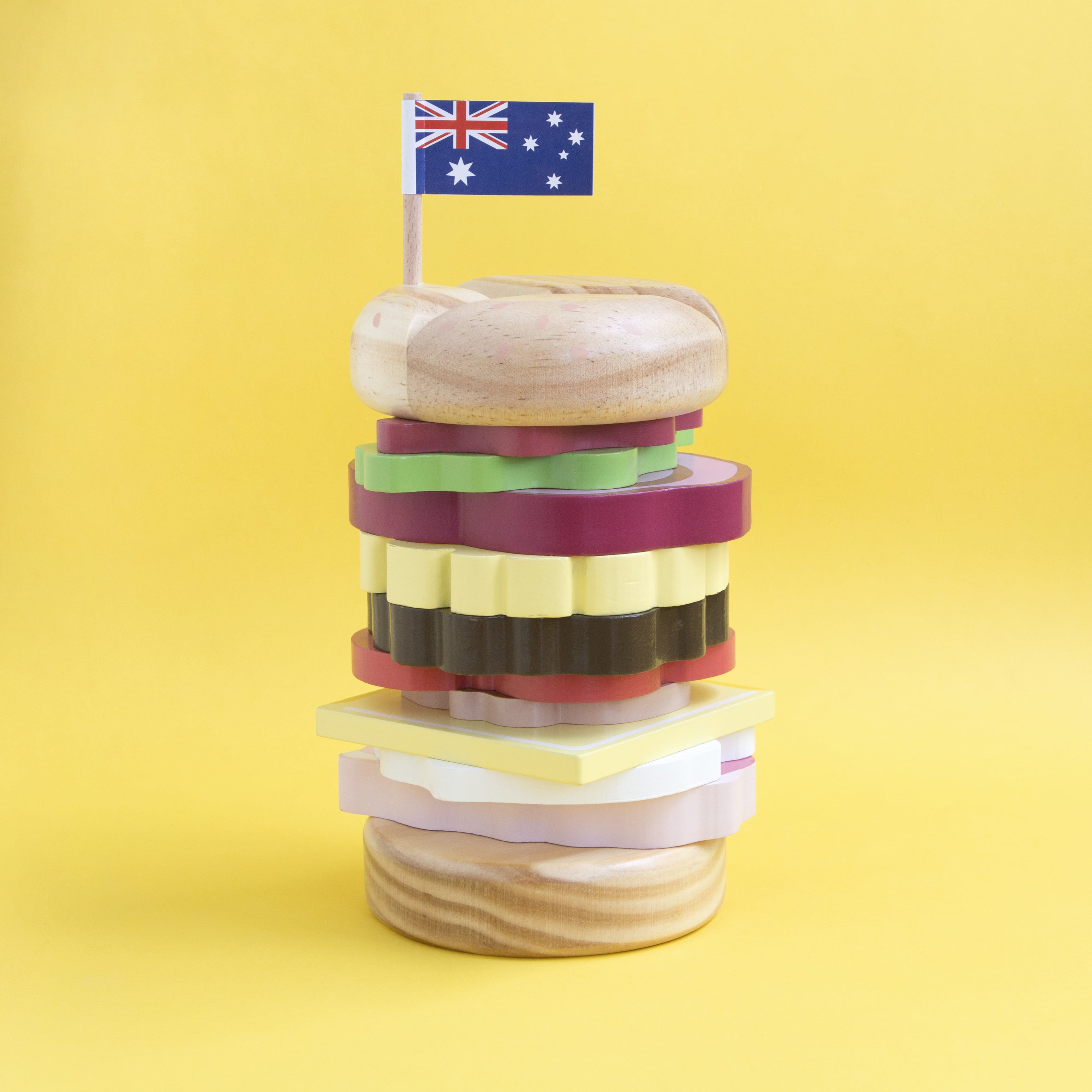Wooden Aussie stacking burger toy for kids with colourful layers, mini flags, and chunky pieces—perfect for imaginative food play and motor skill development.
