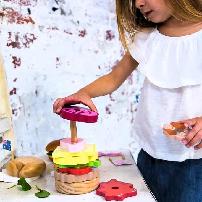 Wooden Aussie stacking burger toy for kids with colourful layers, mini flags, and chunky pieces—perfect for imaginative food play and motor skill development.