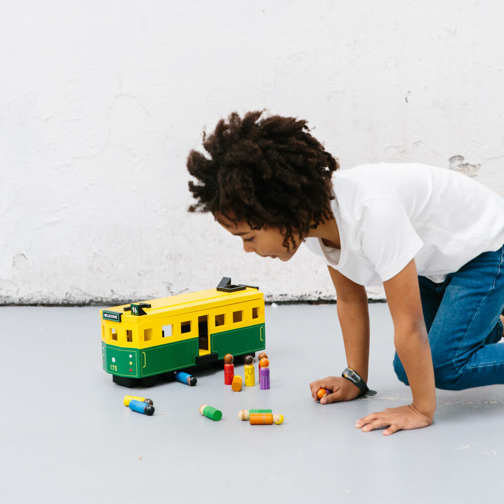 Wooden Melbourne tram toy inspired by the W-Class tram, featuring green and gold detailing, rolling wheels, removable roof, and 14 wooden passenger figures.