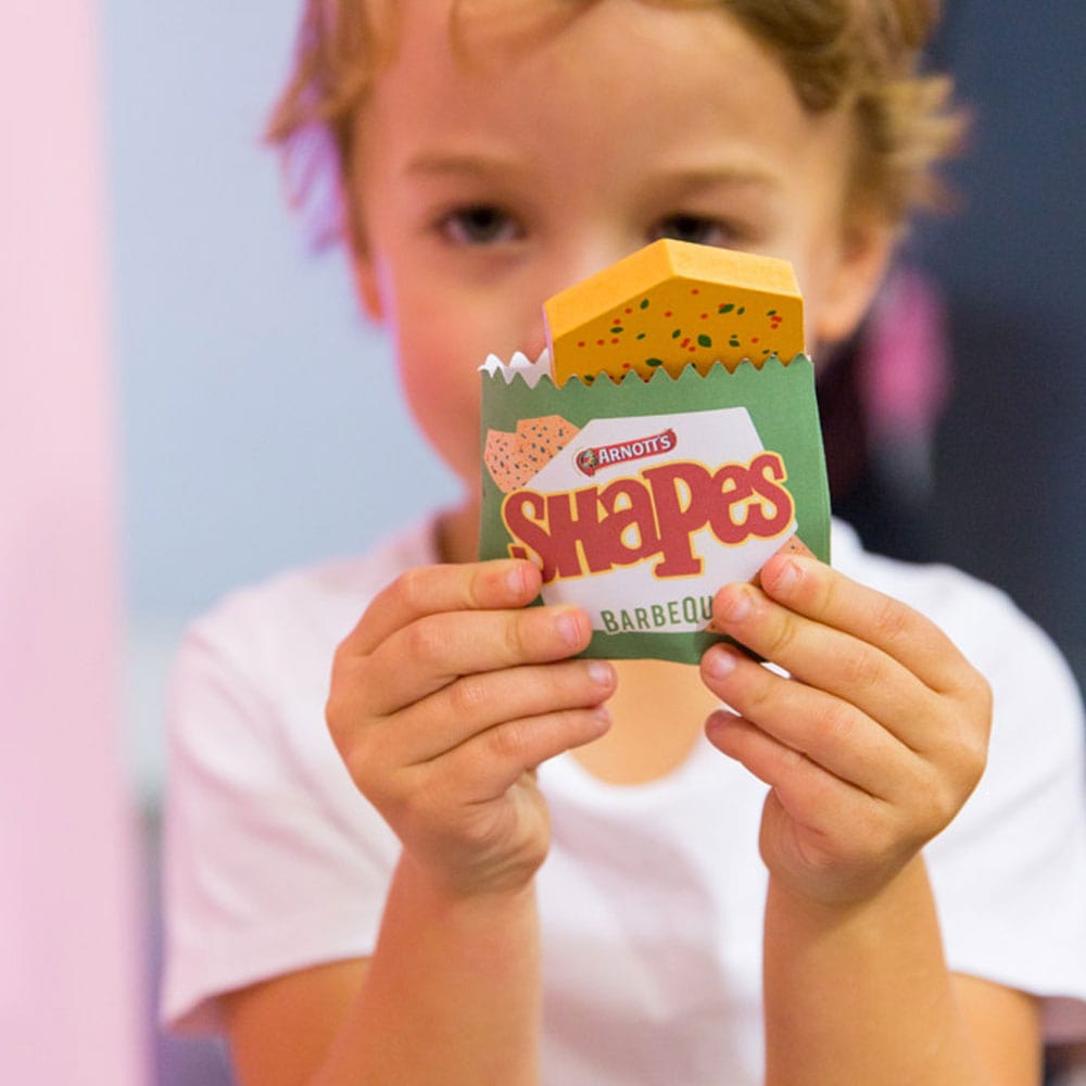 Australian Arnott’s Shapes set wooden toy with Barbecue, Pizza, and Chicken Crimpy biscuits, matching games, counting activities, and mini paper bags for pretend play.

