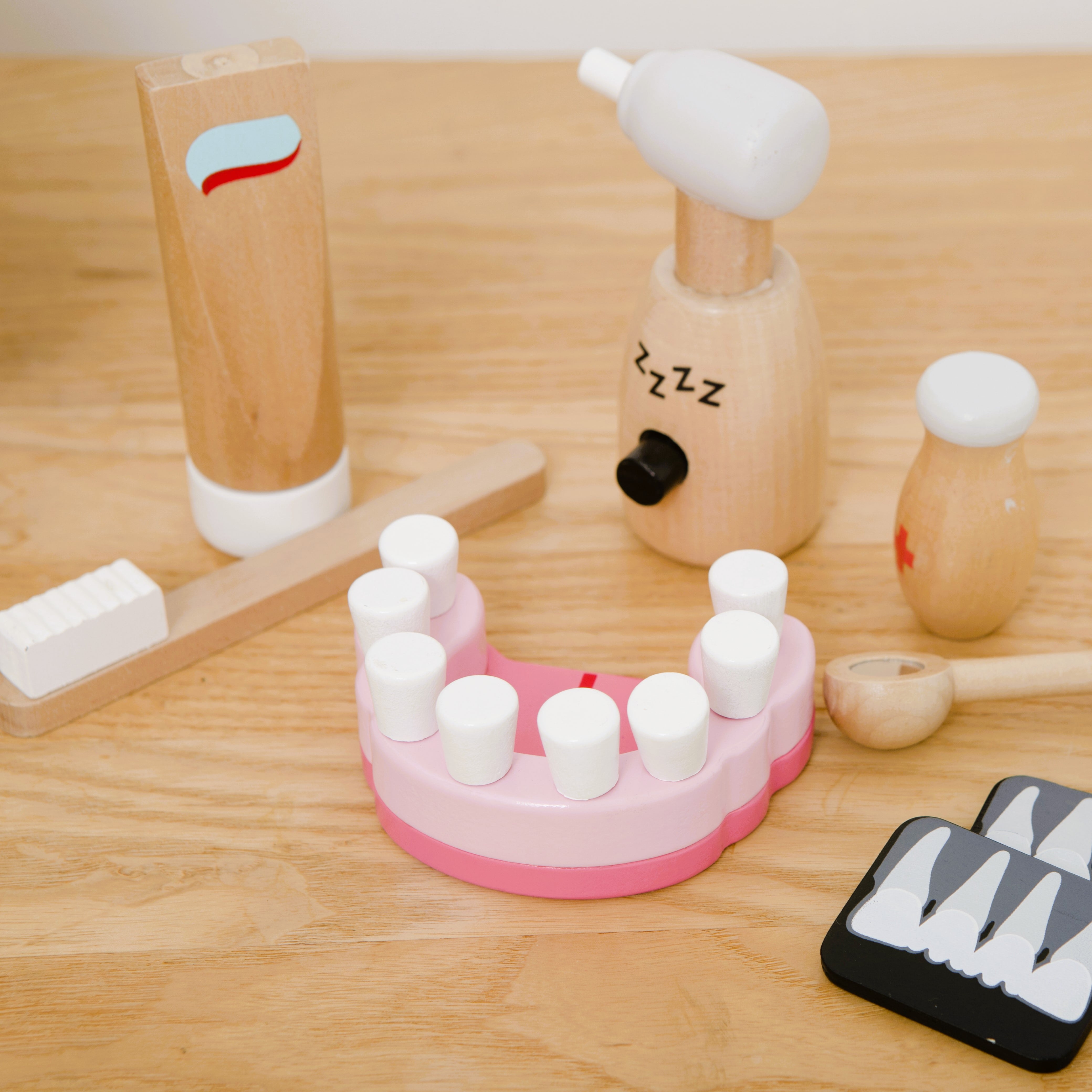Wooden toy dentist kit with model mouth, removable teeth, dental tools, and carry box for imaginative pretend play
