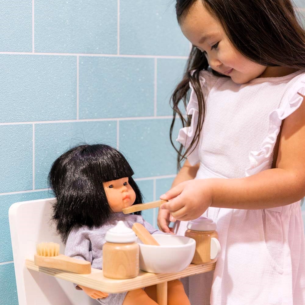 Make Me Iconic 11-piece wooden doll accessory kit with bottles, sippy cup, bowl, fork, spoon, brush with real bristles, comb, teether, and clip-on pacifier – perfect for pretend play.