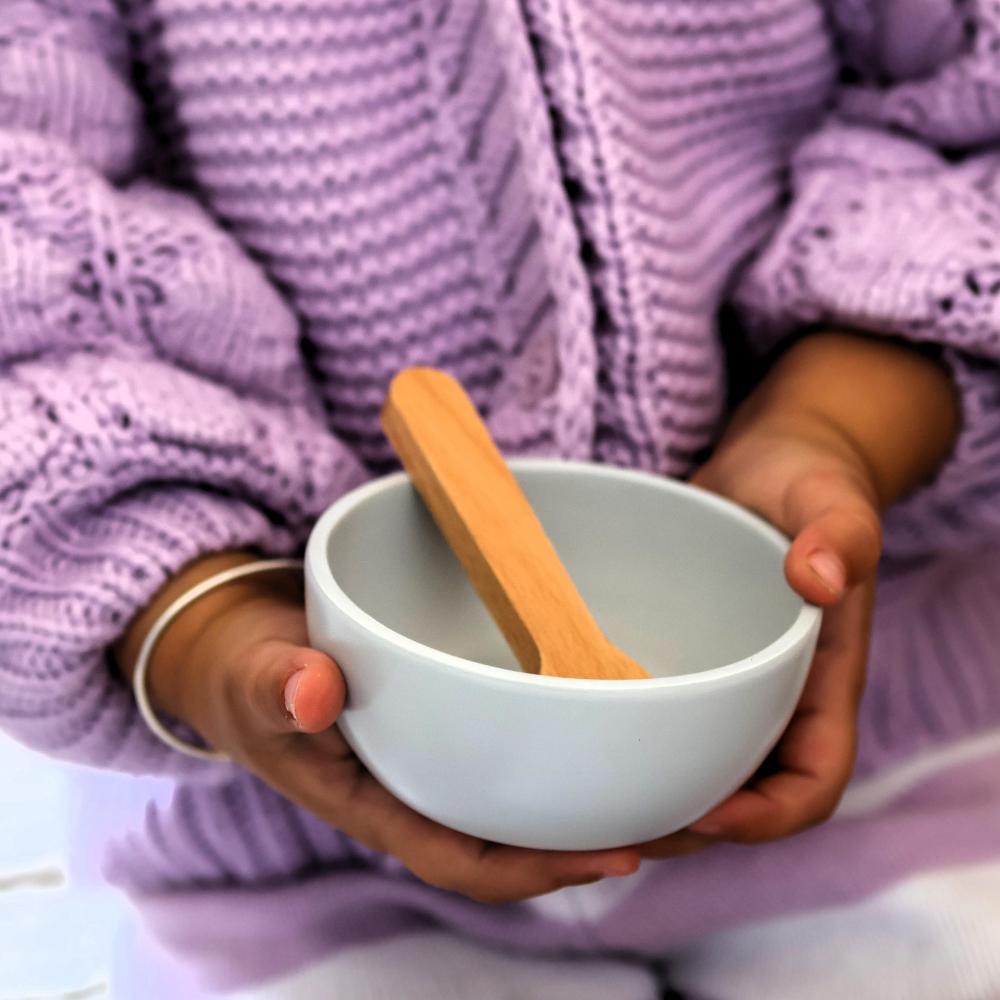 Make Me Iconic 11-piece wooden toy doll accessory kit with bottles, sippy cup, bowl, fork, spoon, brush with real bristles, comb, teether, and clip-on pacifier, perfect for pretend play.