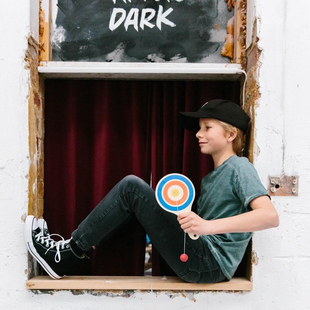 Make Me Iconic wooden paddle ball toy with elastic rubber ball, designed for solo play and developing hand-eye coordination. A classic retro toy perfect for travel, parties, or active play at home.