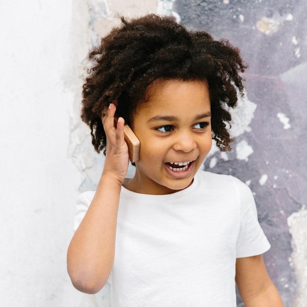 Make Me Iconic Wooden Toy Phone from the Loose Change Range, featuring a realistic design for pretend selfies, texting, and calls. Encourages imaginative, screen-free play for kids who love to copy the grown-ups.