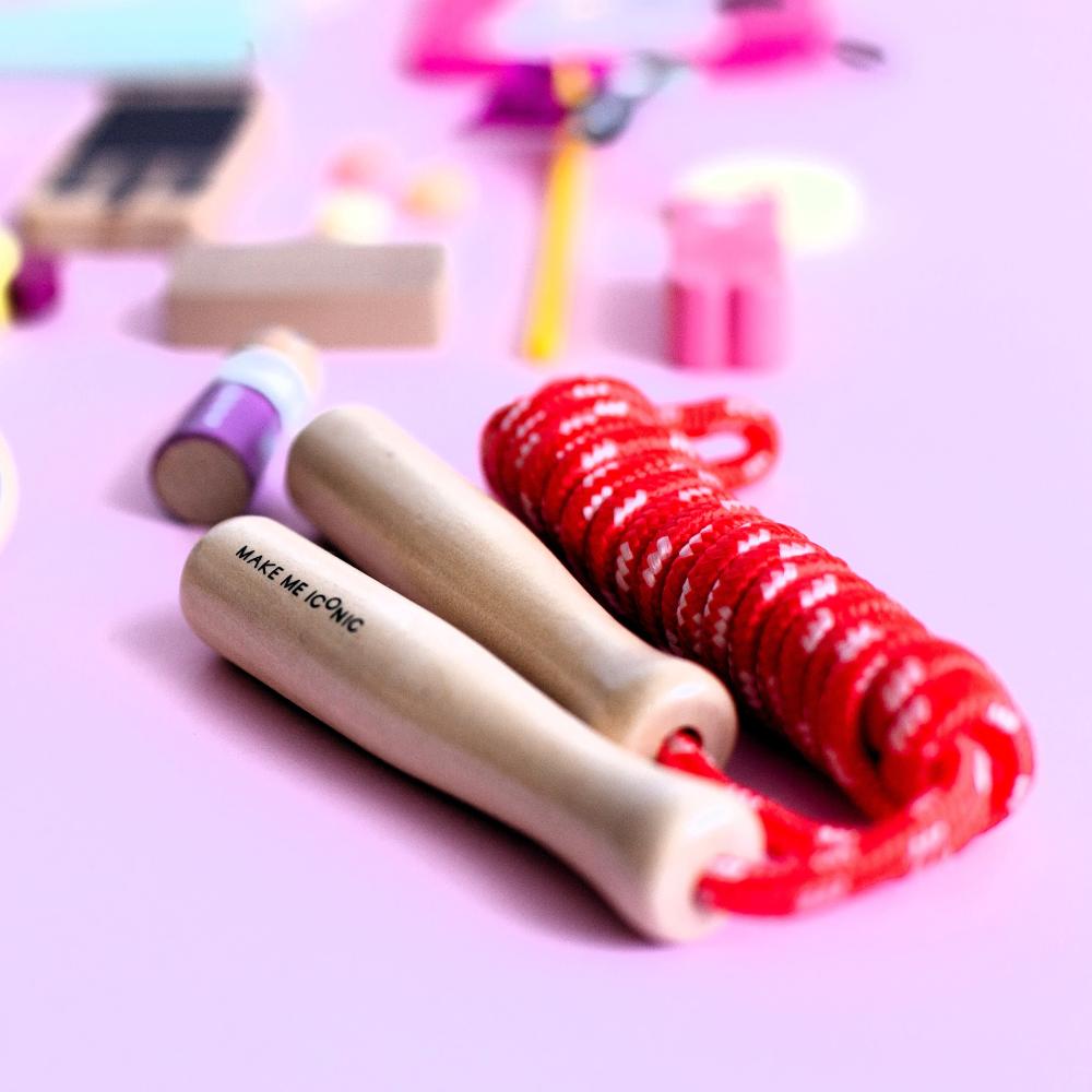 Make Me Iconic wooden skipping rope with smooth natural handles and red-coloured rope, designed for active play, coordination, and classic childhood fun.