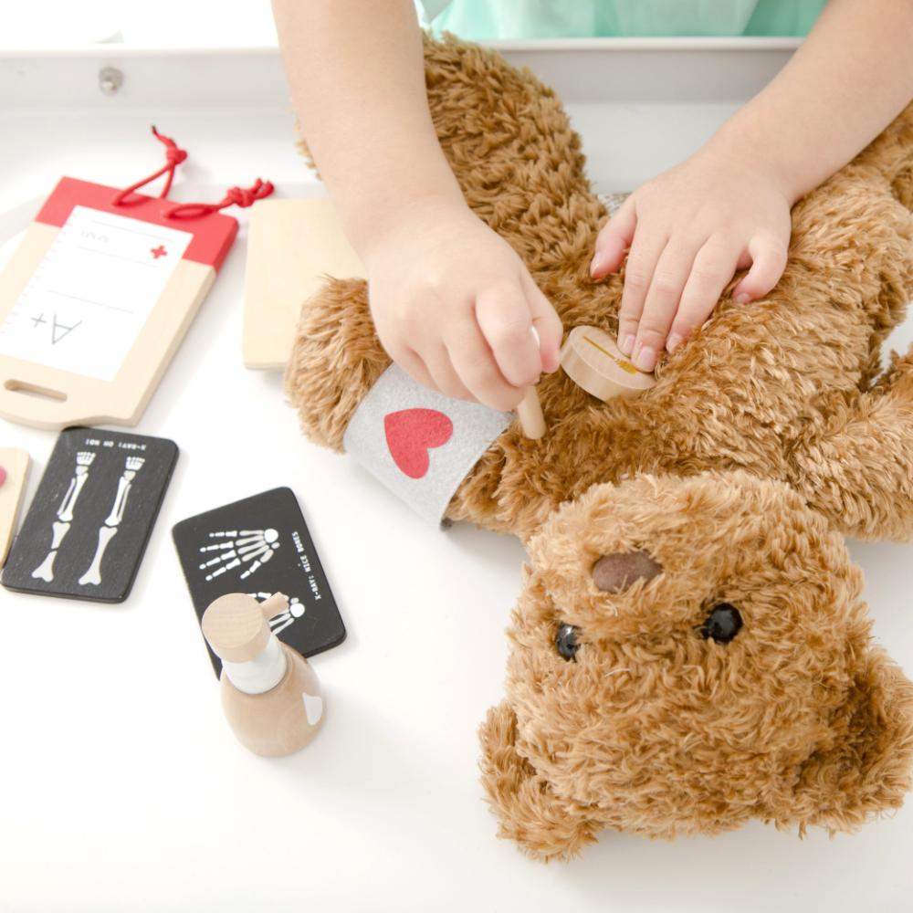 Make Me Iconic Wooden Surgeon Kit featuring toy surgical tools, mini X-rays, and first aid accessories. Inspires imaginative medical play, empathy, and storytelling fun.