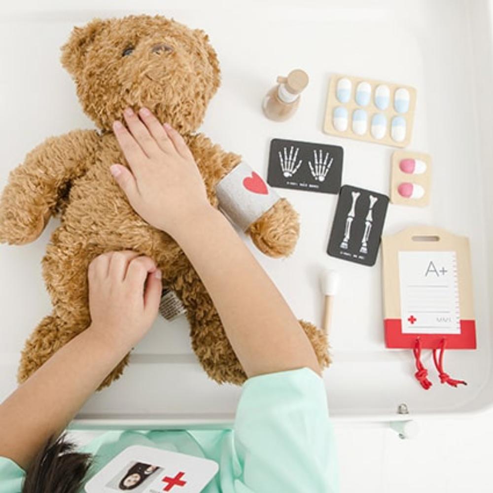 Make Me Iconic Wooden Surgeon Kit featuring toy surgical tools, mini X-rays, and first aid accessories. Inspires imaginative medical play, empathy, and storytelling fun.