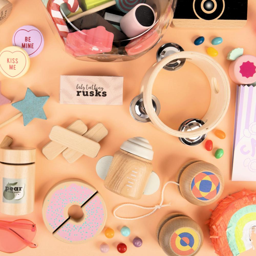 Make Me Iconic 1-piece wooden toy tambourine with a classic round design, perfect for musical pretend play. Encourages young kids to explore rhythm, coordination, and creative expression through music.