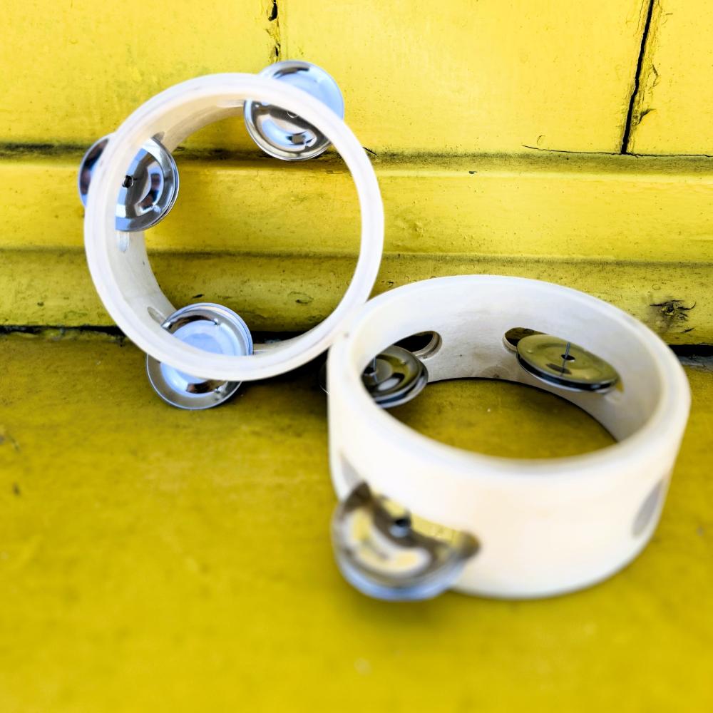 Make Me Iconic 1-piece wooden toy tambourine with a classic round design, perfect for musical pretend play. Encourages young kids to explore rhythm, coordination, and creative expression through music.