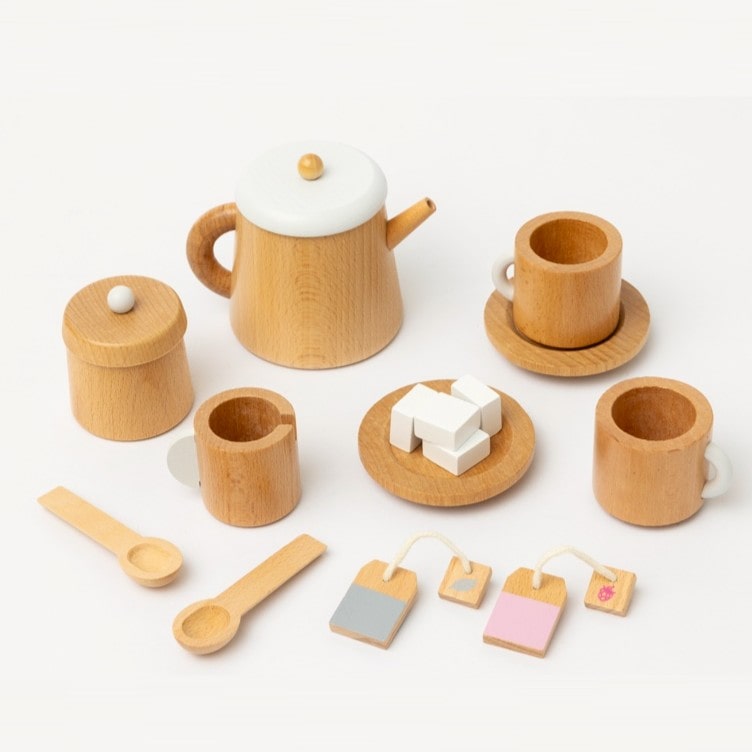 Wooden toy tea set for kids featuring teapot, cups, saucers, spoons, sugar bowl and milk jug, designed for pretend play, café role-play, and social learning activities.