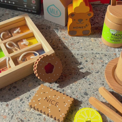 Make Me Iconic 27-piece wooden toy Tea Set Extension Set with tea cups, tea bags, tongs, cookies, and accessories. Ideal for pretend play and perfectly matched with our wooden toy Tea Set.