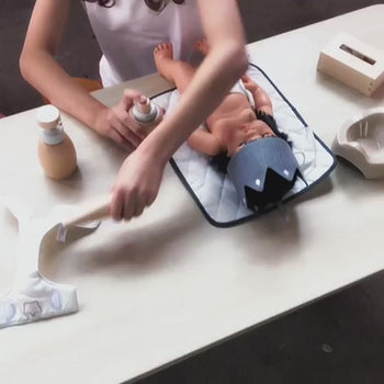 Wooden toy Doll Nurturing Kit made of wood and fabric for kids with potty, wipes, nappies, and accessories designed for pretend play, nurturing, and hands-on role-play activities.